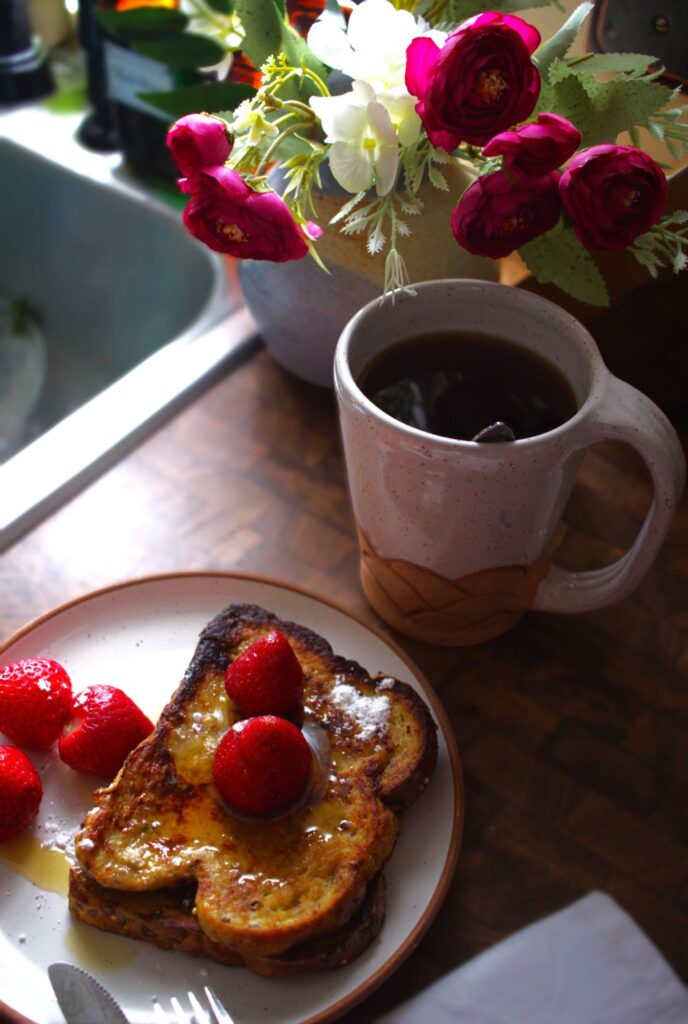 French toast and coffee on ceramic pottery plate and cup