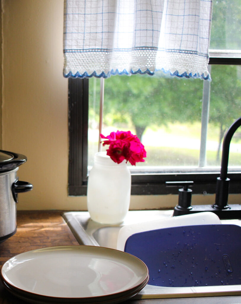 dinner plate by the kitchen window and a vase of flowers