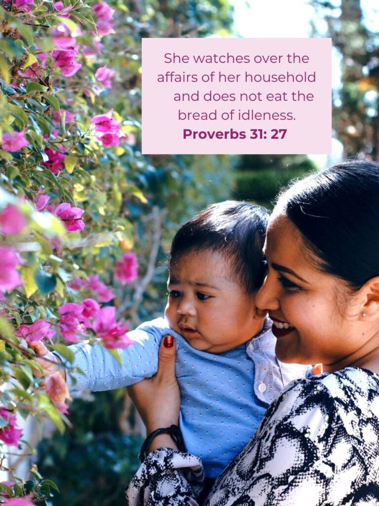 woman holding a baby picking flowers