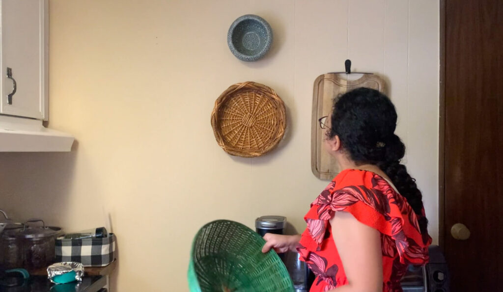 Woman decorating the kitchen with baskets