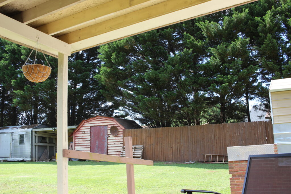 old broken down storage unit in a yard 